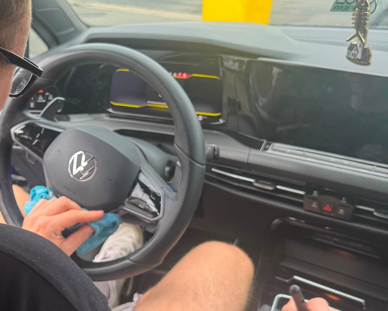 Lenkrad und Armaturenbrett eines VW Golf R werden von Hand gereinigt