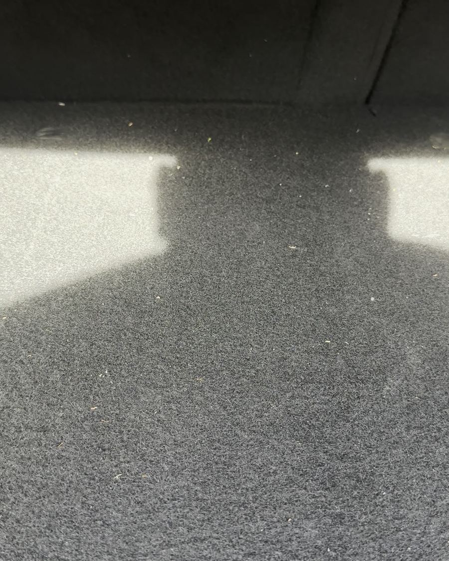 Kofferraumboden des Maserati Ghibli vor der Reinigung, mit Staub und Flusen